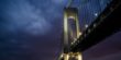 Bridge at night with lights on with background view of the sky.